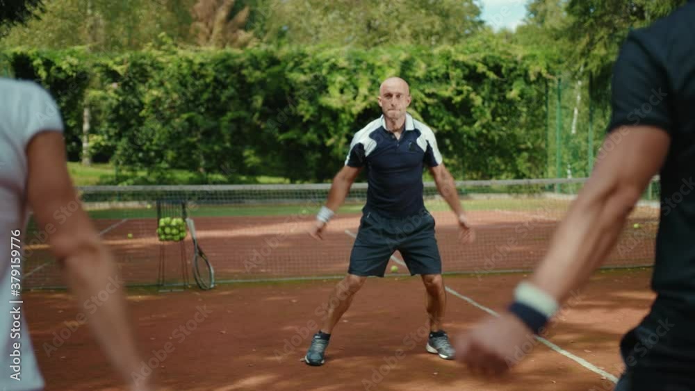 Players warm up jumping before a game of tennis with trainer success match training course exercise fitness man woman athlete fun sport court summer close up slow motion Players warm up jumping before a game of tennis with trainer success match training course exercise fitness man woman athlete fun sport court summer close up slow motion