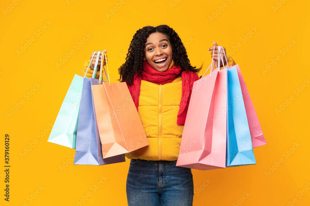 Excited Lady With Shopping Bags Posing Wearing Jacket, Yellow Background