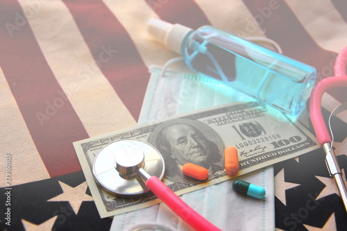 setehoscope with medicines  on American dollar  with mask and alcohol spray flag background,healthy concept