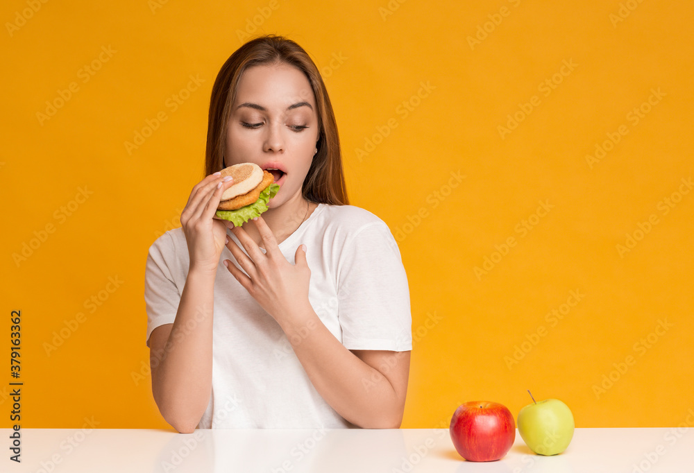 Hungry Lady Eating Unhealthy Burger Instead Of Apple Fruit Hungry Lady Eating Unhealthy Burger Instead Of Apple Fruit