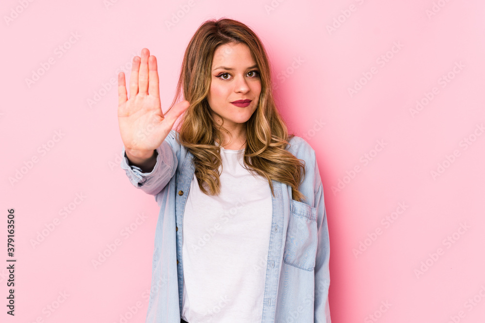 Young caucasian woman isolated on pink background standing with outstretched hand showing stop sign, preventing you. Young caucasian woman isolated on pink background standing with outstretched hand showing stop sign, preventing you.