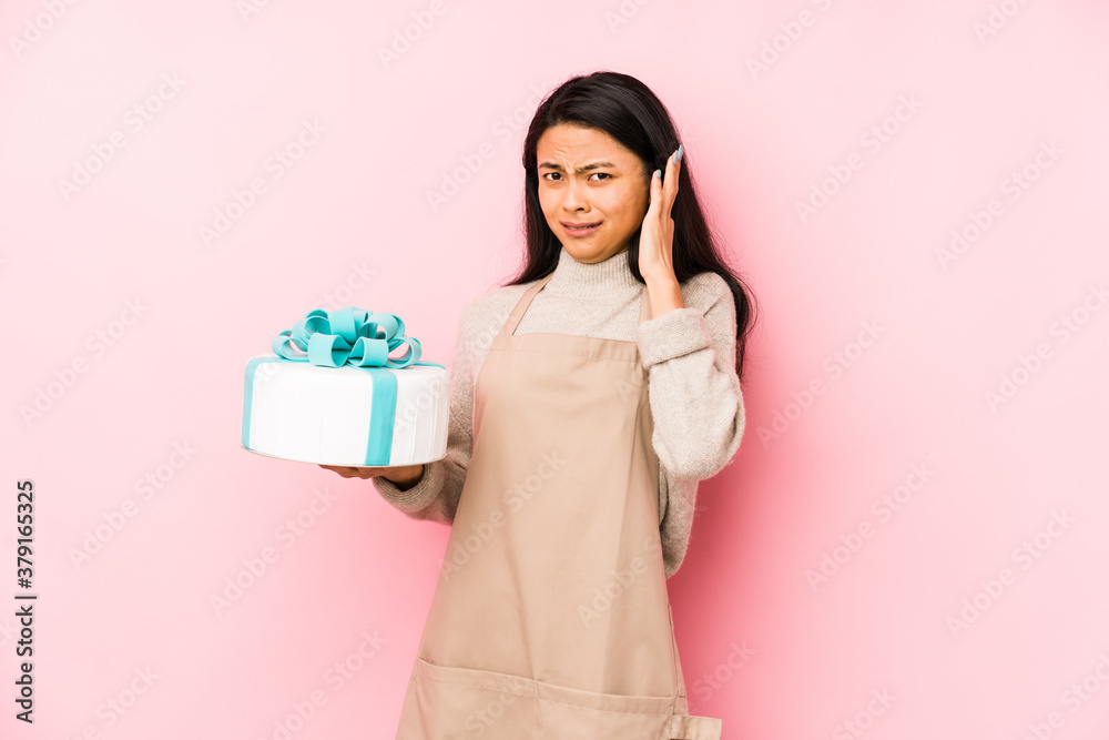 Young chinese woman holding a cake isolated having some great idea, concept of creativity. Young chinese woman holding a cake isolated having some great idea, concept of creativity.