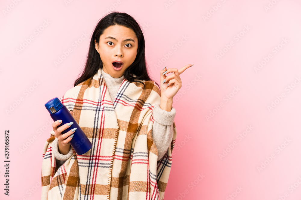 Young chinese woman doing a camping isolated on pink background is saying a secret hot braking news and looking aside Young chinese woman doing a camping isolated on pink background is saying a secret hot braking news and looking aside