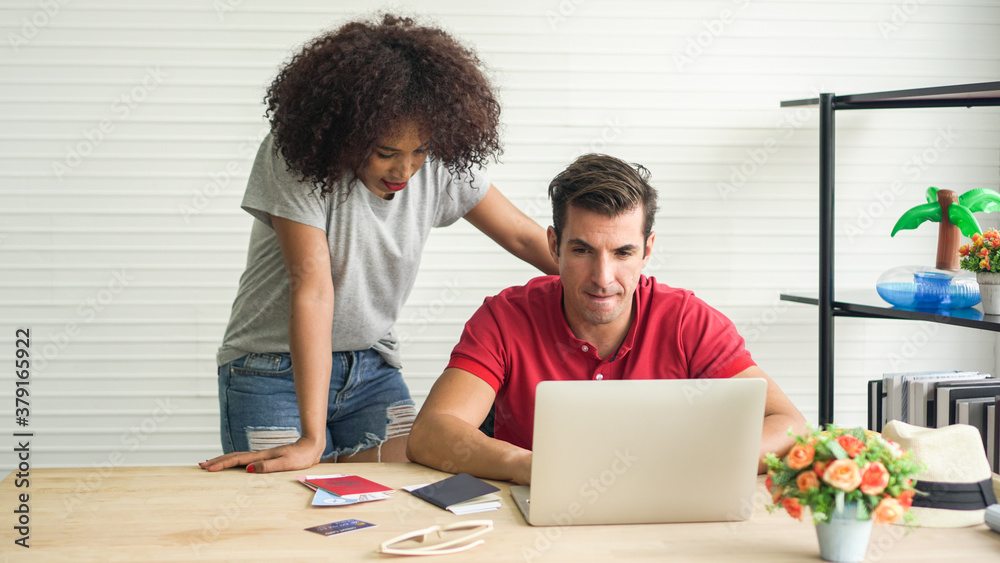 Interracial couple African and Hispanic planning a fun Summer trip together booking with passport online