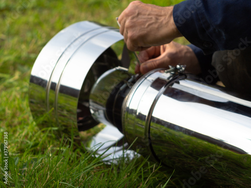 installing the deflector on the heating pipe. sandwich pipes. construction. hands in the frame