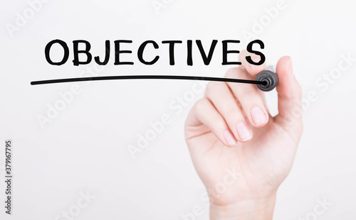 Hand writing objectives with black marker on transparent wipe board
