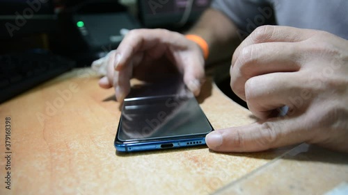  someone changes the protective glass on a mobile phone