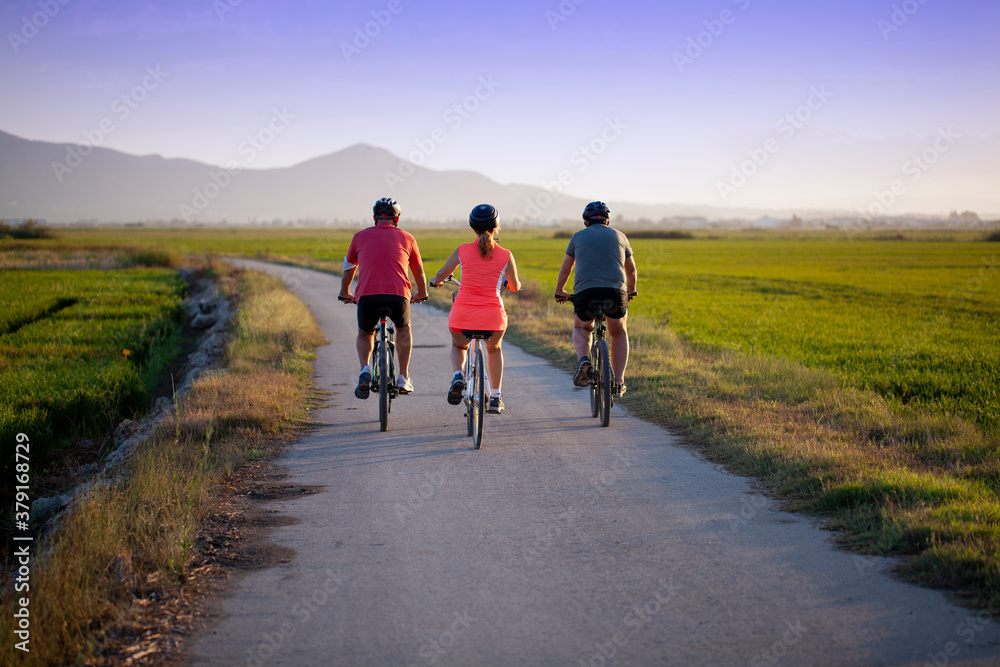 Fototapeta premium Ciclistas al atardecer en camino solitario