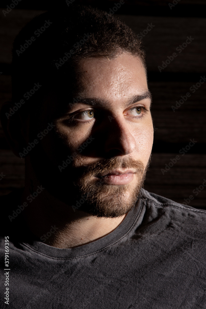 Retrato do rosto de um homem de barba com sombra do lado direito e o lado esquerdo iluminado. Modelo. Retrato do rosto de um homem de barba com sombra do lado direito e o lado esquerdo iluminado. Modelo.