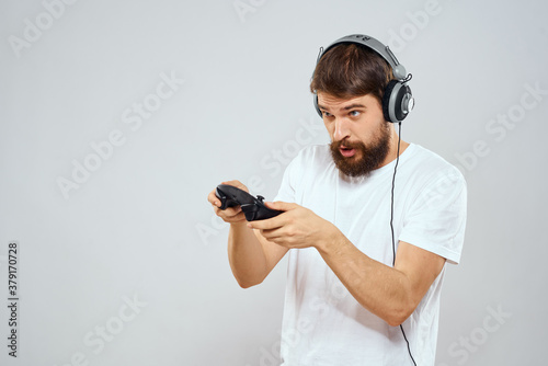 Man in headphones with gamepad playing hobby entertainment lifestyle light background