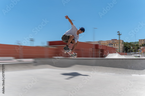 Hombre joven hace un salto con su tabla en un parque de skateboard en un dia soledado 4 photo