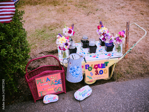 A sidewalk flower stand sells bouquets of fresh cut flowers. photo