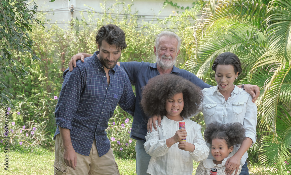 Multi ethnic caucasian - african family group relax taking a walk and prepare for celebration together on holiday at backyard house with happy smiling face. Selective focus. Multi ethnic caucasian - african family group relax taking a walk and prepare for celebration together on holiday at backyard house with happy smiling face. Selective focus.