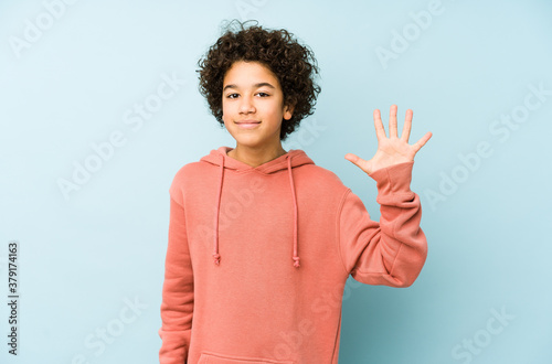 African american little boy isolated smiling cheerful showing number five with fingers. photo