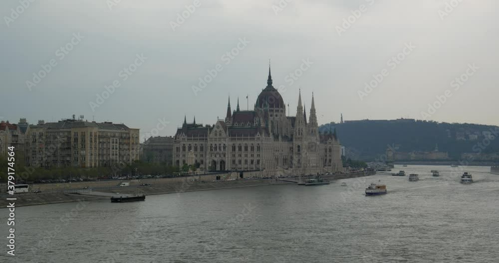 Budapest parliament from one side, other side of the Danube river with some boats sailing. Budapest parliament from one side, other side of the Danube river with some boats sailing.