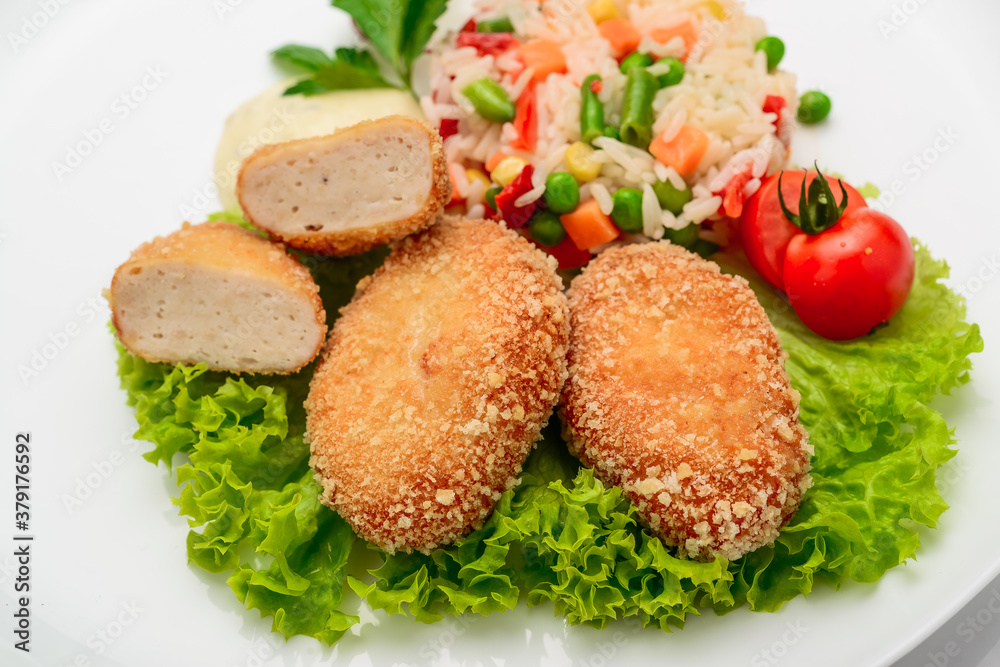 Chicken cutlets in batter with risotto and vegetables