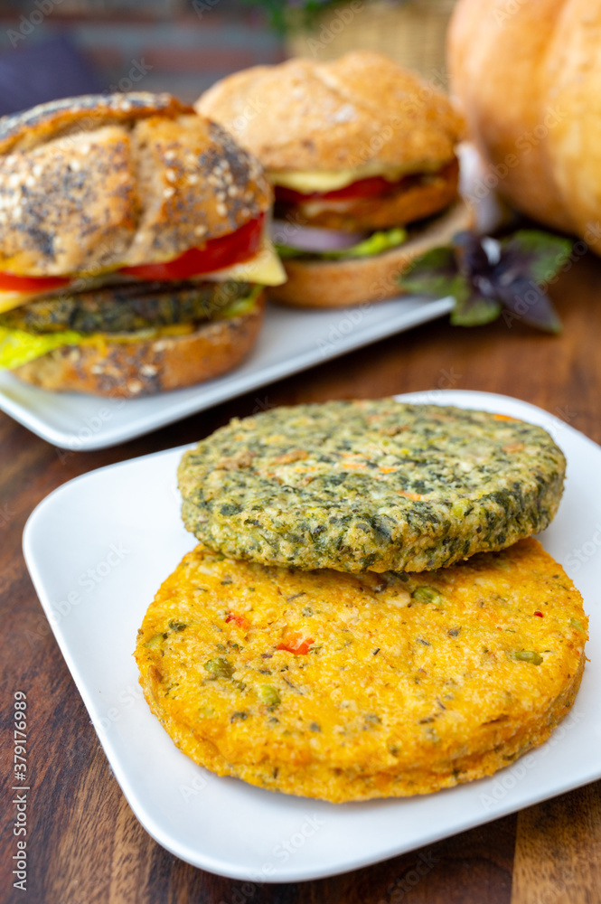 Making fresh and healthy vegetarian hamburgers with grilled spinach or pumpkin burgers, organic buns and vegetables Making fresh and healthy vegetarian hamburgers with grilled spinach or pumpkin burgers, organic buns and vegetables