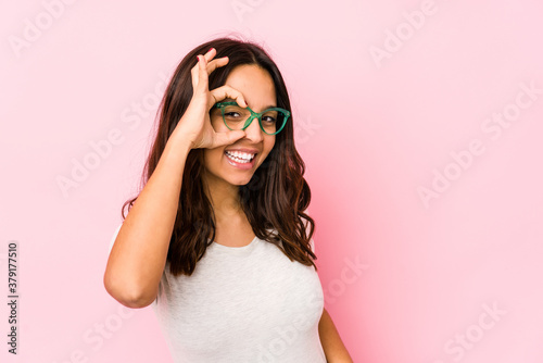 Young mixed race hispanic woman isolated excited keeping ok gesture on eye. © Asier