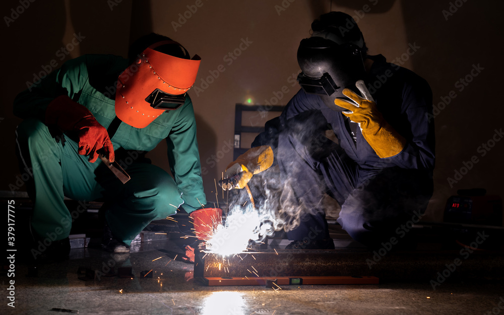 Professional repair workers repair metal parts by electric welding in an factory industrial.