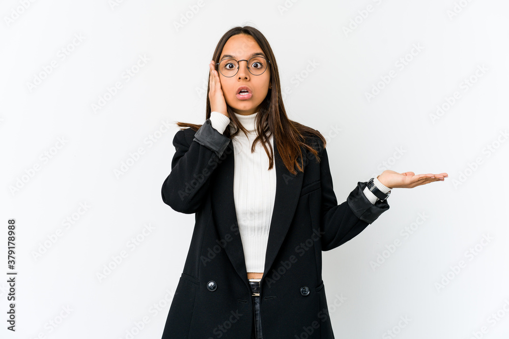 Young mixed race business woman isolated on white background impressed holding copy space on palm.