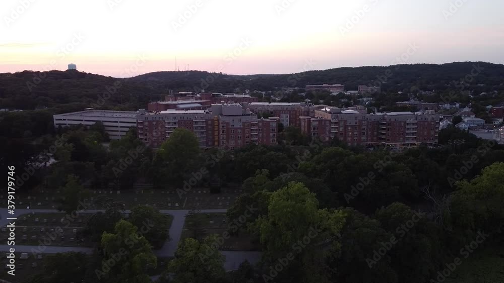 Sweeping view of an apartment complex near a cemetary at dusk. Sweeping view of an apartment complex near a cemetary at dusk.