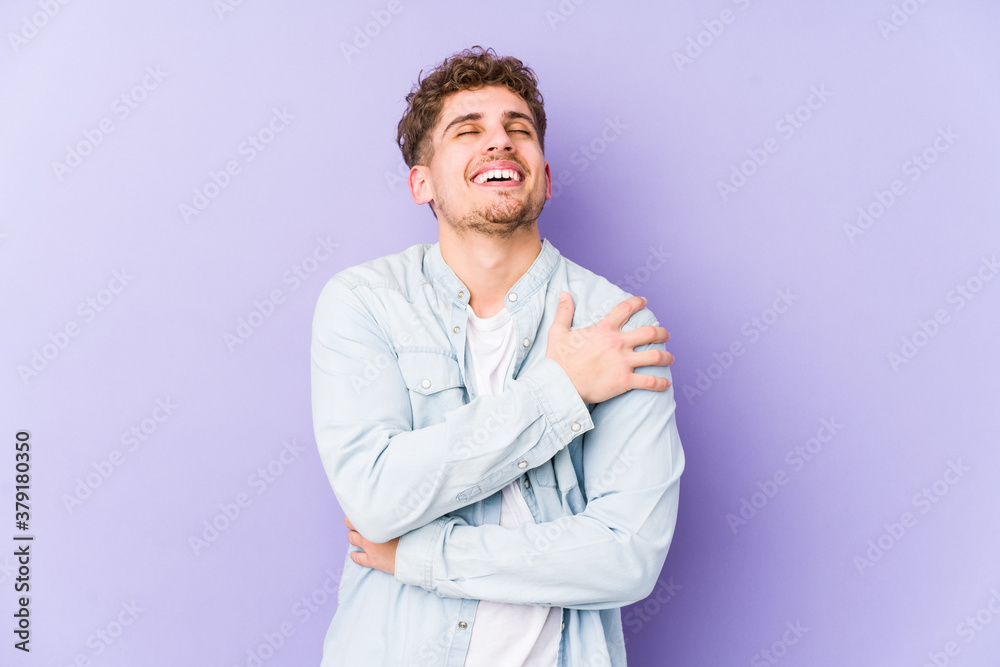 Young blond curly hair caucasian man isolated hugs, smiling carefree and happy. Young blond curly hair caucasian man isolated hugs, smiling carefree and happy.