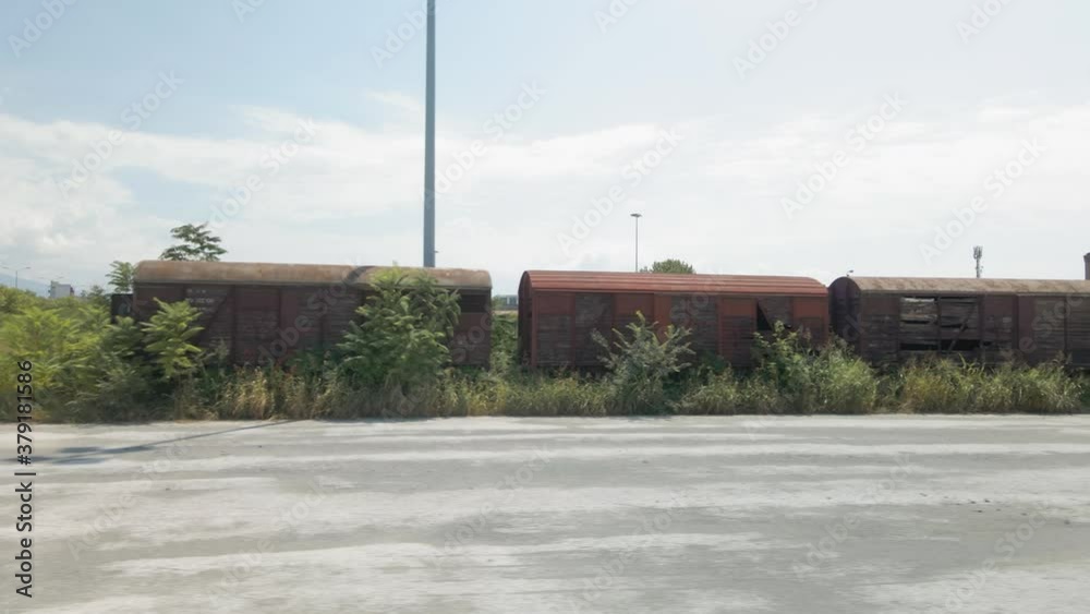 Aerial drone landscape of abandoned commercial train wagons with old locomotive. Top panorama of goods connected vehicles used for freight transport parked on a railway track in Thessaloniki, Greece. Aerial drone landscape of abandoned commercial train wagons with old locomotive. Top panorama of goods connected vehicles used for freight transport parked on a railway track in Thessaloniki, Greece.