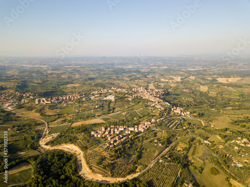 Aerial/Drone panorama of San Gimignano in the tuscany and its vineyards and olive trees that surround it, Italy