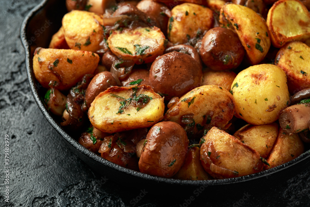Baked potato with mushrooms and herbs in iron cast pan Baked potato with mushrooms and herbs in iron cast pan