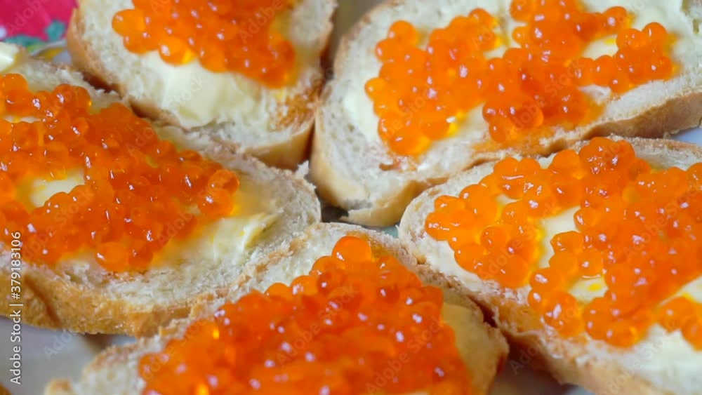 several sandwiches with red caviar rotate on a plate. close-up. several sandwiches with red caviar rotate on a plate. close-up.