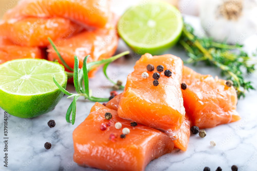 Fresh raw salmon fillet on black cutting board with lemon and spices. Healthy food concept. Close up view Fresh raw salmon fillet on black cutting board with lemon and spices. Healthy food concept. Close up view