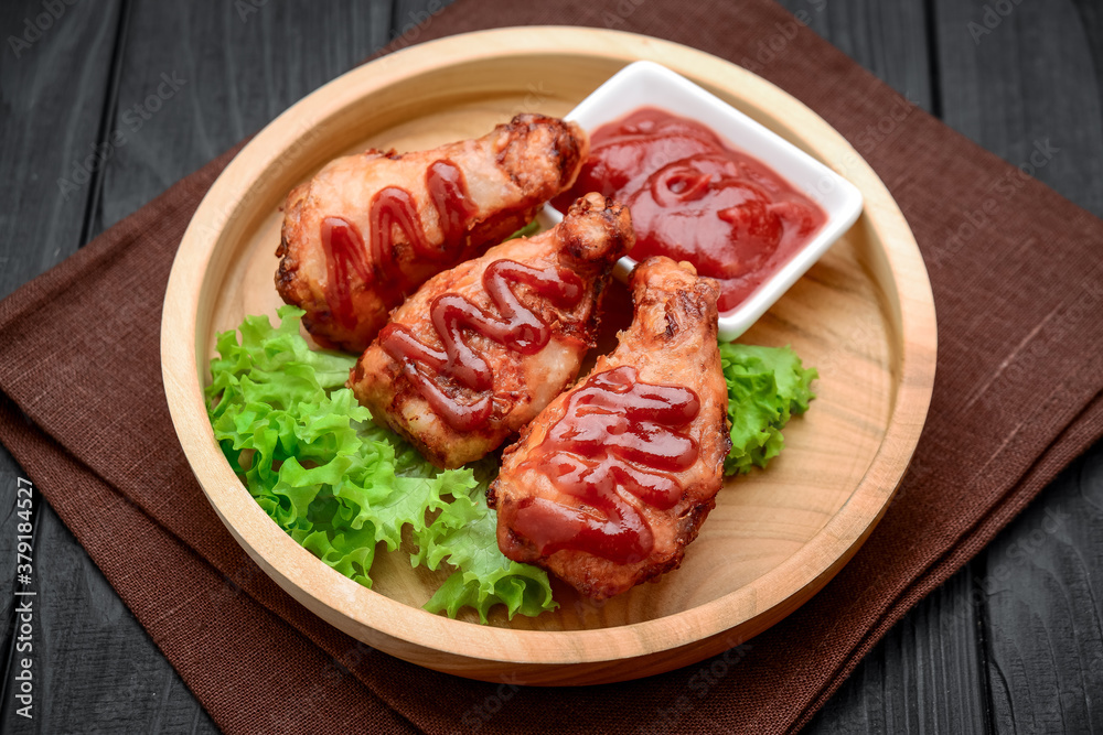 Chicken wings with ketchup on a wooden table.