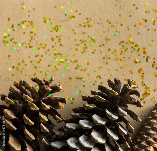 Golden Christmas glitters and pine cones on natural background. Flat lay style. Holiday classic concept.