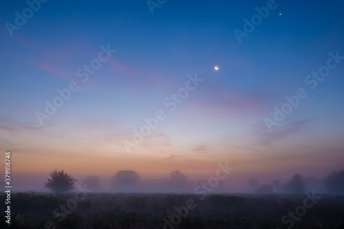 fairy-tale dawn over a hazy autumn meadow