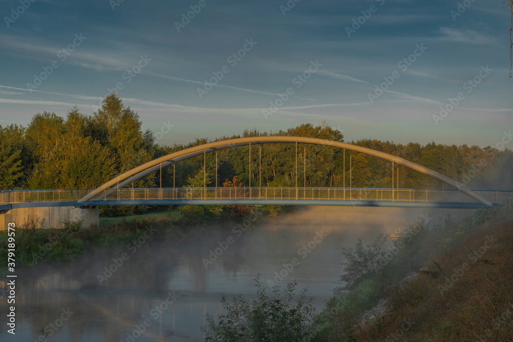 Vltava river with bike bridge and small port in summer cold morning with sun