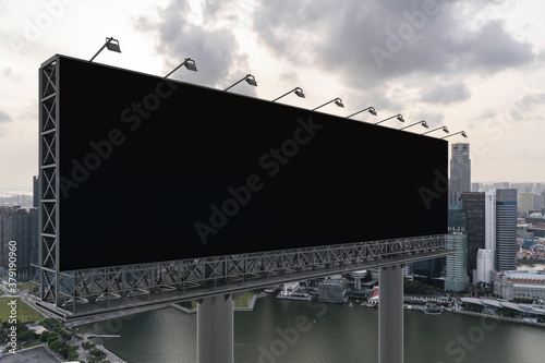 Blank black road billboard with Singapore cityscape background at sunset. Street advertising poster, mock up, 3D rendering. Side view. The concept of marketing communication to sell idea.