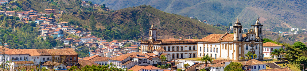 Panoramic view from the top of the historic center of Ouro Preto with its houses, church, monuments and mountains - obrazy, fototapety, plakaty 