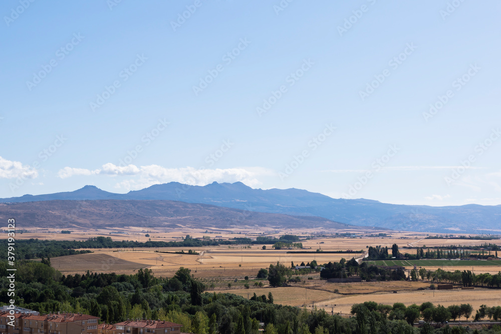 Llanura de Castilla con montañas y cielo al fondo