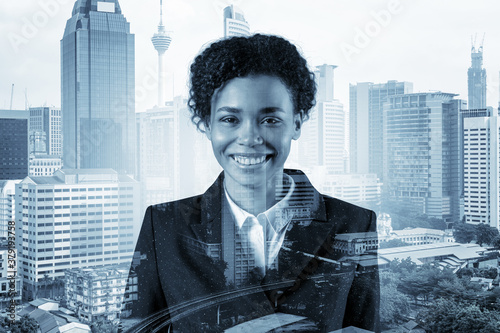 Successful smiling black African American business woman in suit. Kuala Lumpur cityscape. The concept of woman in business. KL skyscrapers. Double exposure. photo