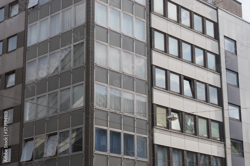 Close-up of the modern concrete glass facade of a business skyscraper with reflections in the windows