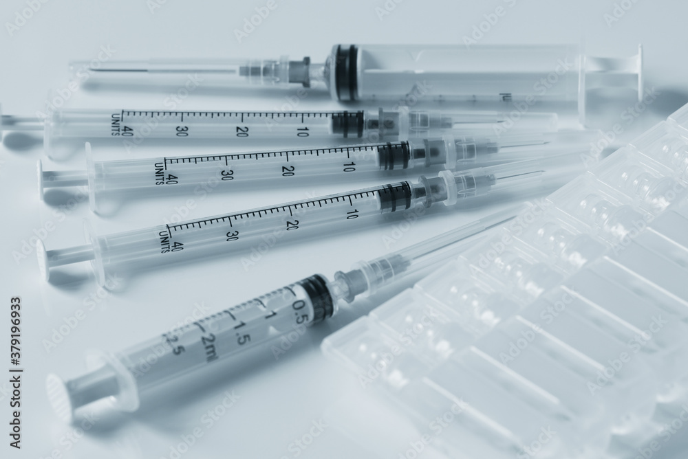 plastic syringes and plastic capsules with medicine are on a white table plastic syringes and plastic capsules with medicine are on a white table