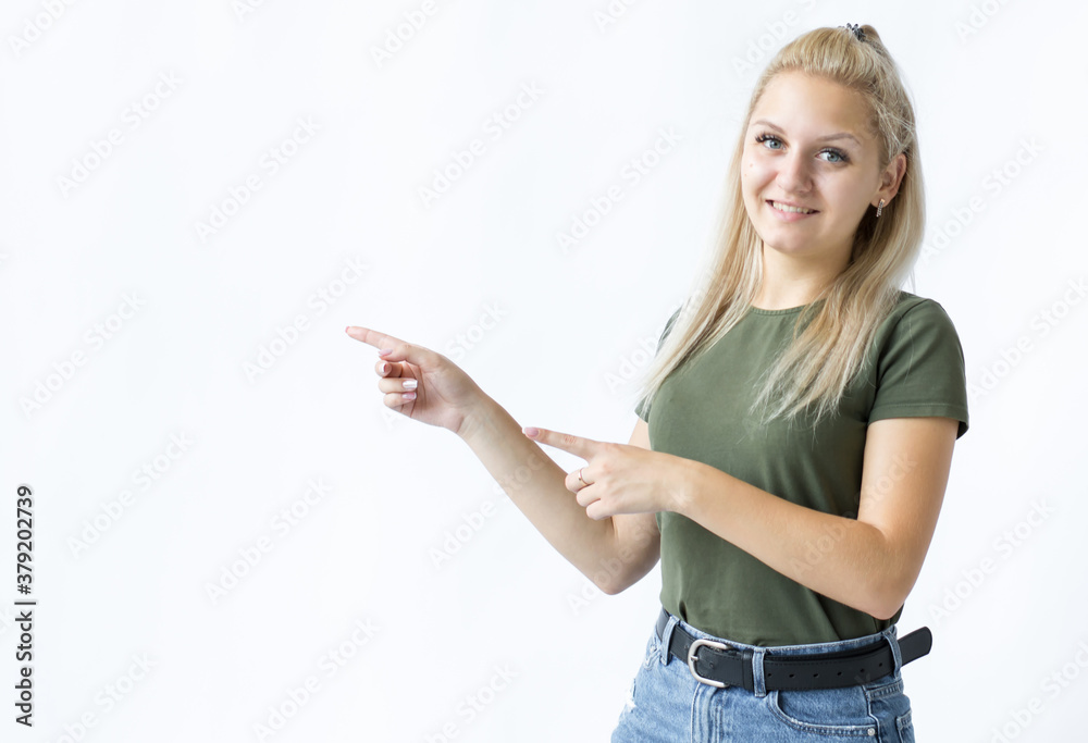 Portrait of a smiling girl who stands spreading her and point one hands to the side on a white background Portrait of a smiling girl who stands spreading her and point one hands to the side on a white background