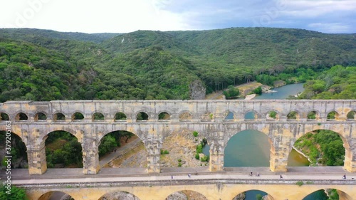 Low altitude aerial of Pont du Gard is an ancient Roman aqueduct that crosses the Gardon River near the town of Vers-Pont-du-Gard in southern France and popular tourist destination 4k