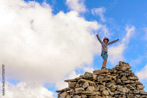 A boy on top of a mountain, happy and joyful, family vacation in the Carpathians, Mount Menchul, the Montenegrin ridge of Ukraine.