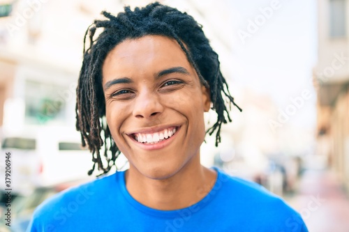 Young african american man smiling happy looking to the camera at street of city.