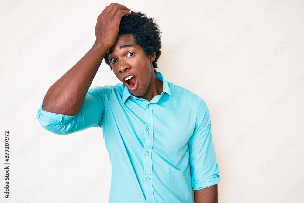 Handsome african american man with afro hair wearing casual clothes surprised with hand on head for mistake, remember error. forgot, bad memory concept. Handsome african american man with afro hair wearing casual clothes surprised with hand on head for mistake, remember error. forgot, bad memory concept.