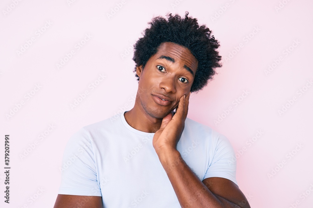Handsome african american man with afro hair wearing casual clothes thinking looking tired and bored with depression problems with crossed arms. Handsome african american man with afro hair wearing casual clothes thinking looking tired and bored with depression problems with crossed arms.