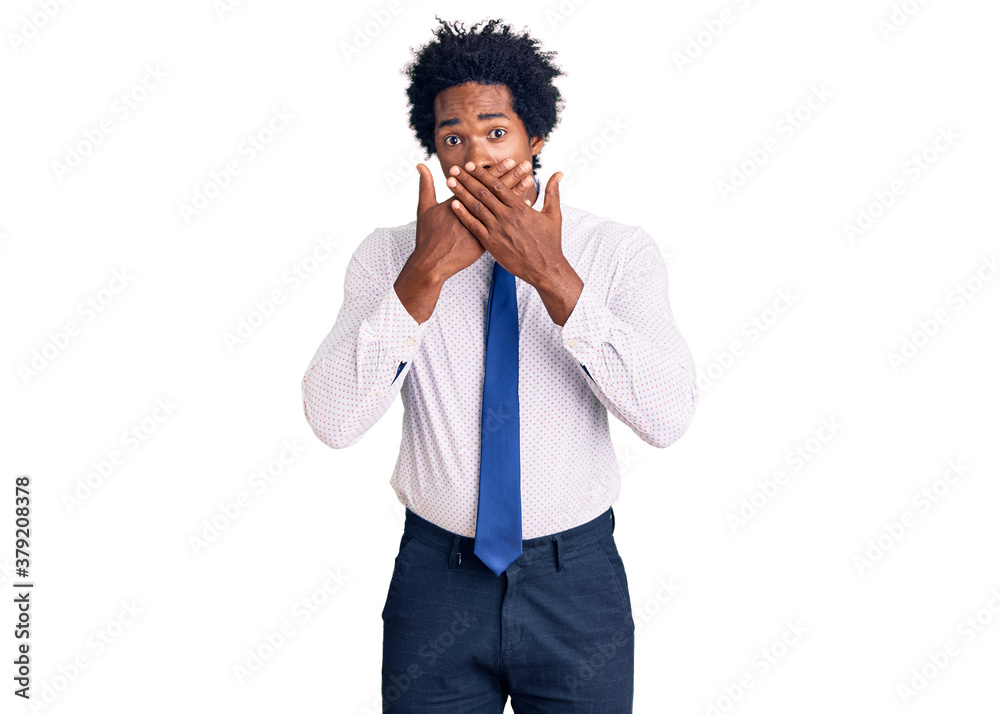 Handsome african american man with afro hair wearing business clothes shocked covering mouth with hands for mistake. secret concept. Handsome african american man with afro hair wearing business clothes shocked covering mouth with hands for mistake. secret concept.