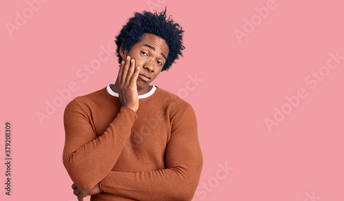 Handsome african american man with afro hair wearing casual clothes thinking looking tired and bored with depression problems with crossed arms.