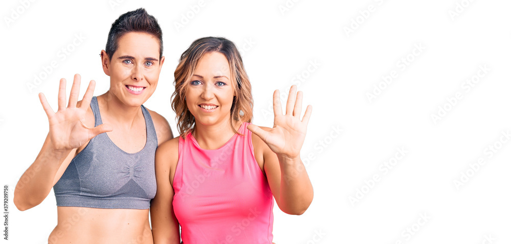 Couple of women wearing sportswear showing and pointing up with fingers number ten while smiling confident and happy. Couple of women wearing sportswear showing and pointing up with fingers number ten while smiling confident and happy.